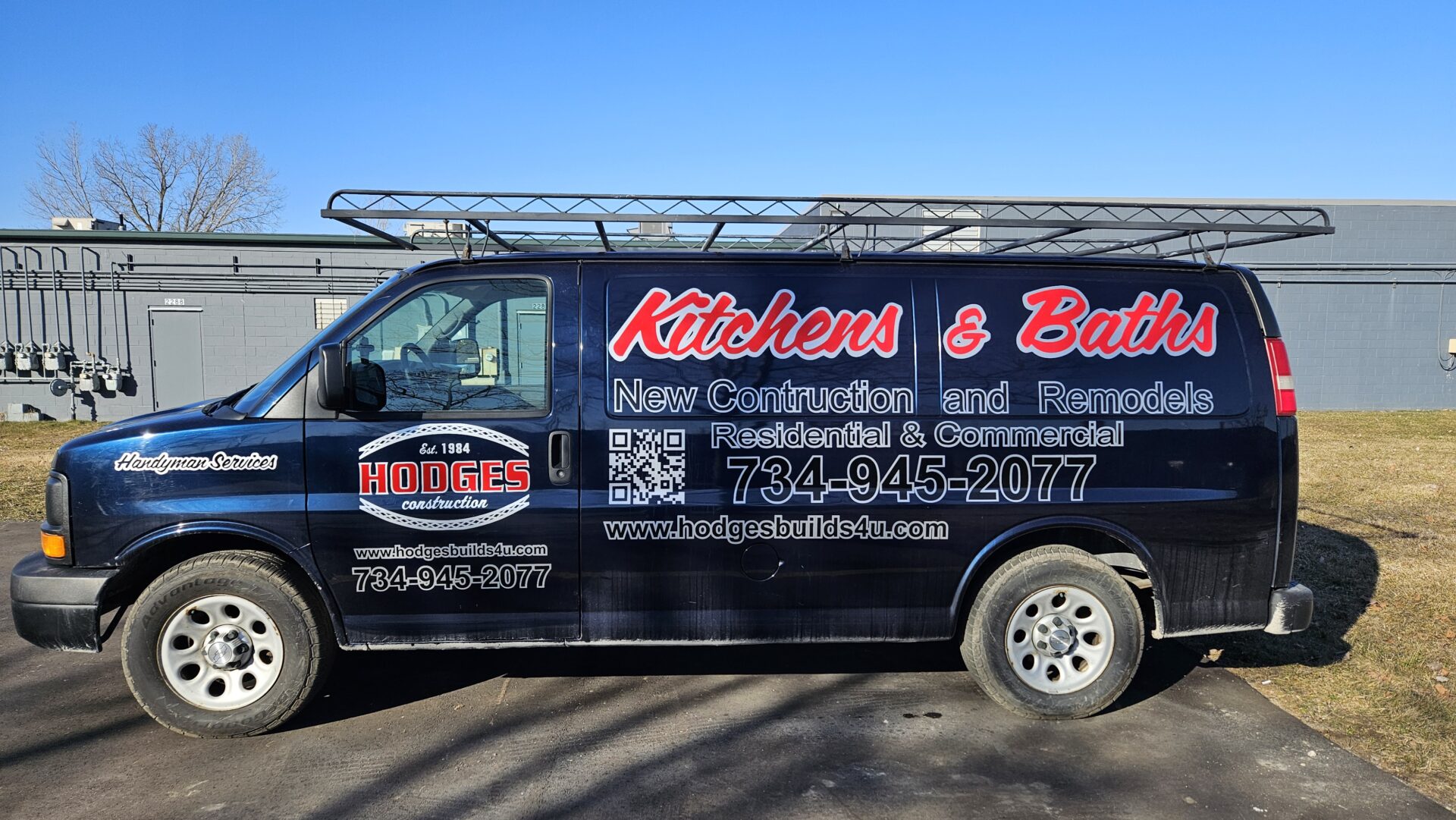 A black van with red and white Vinyl Signs & Banners Ann Arbor writing on it.